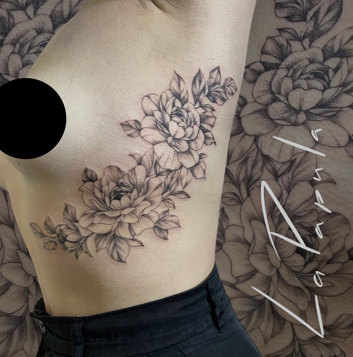 Fine-line tattoo of two blooming peonies with leaves on the side of the body.